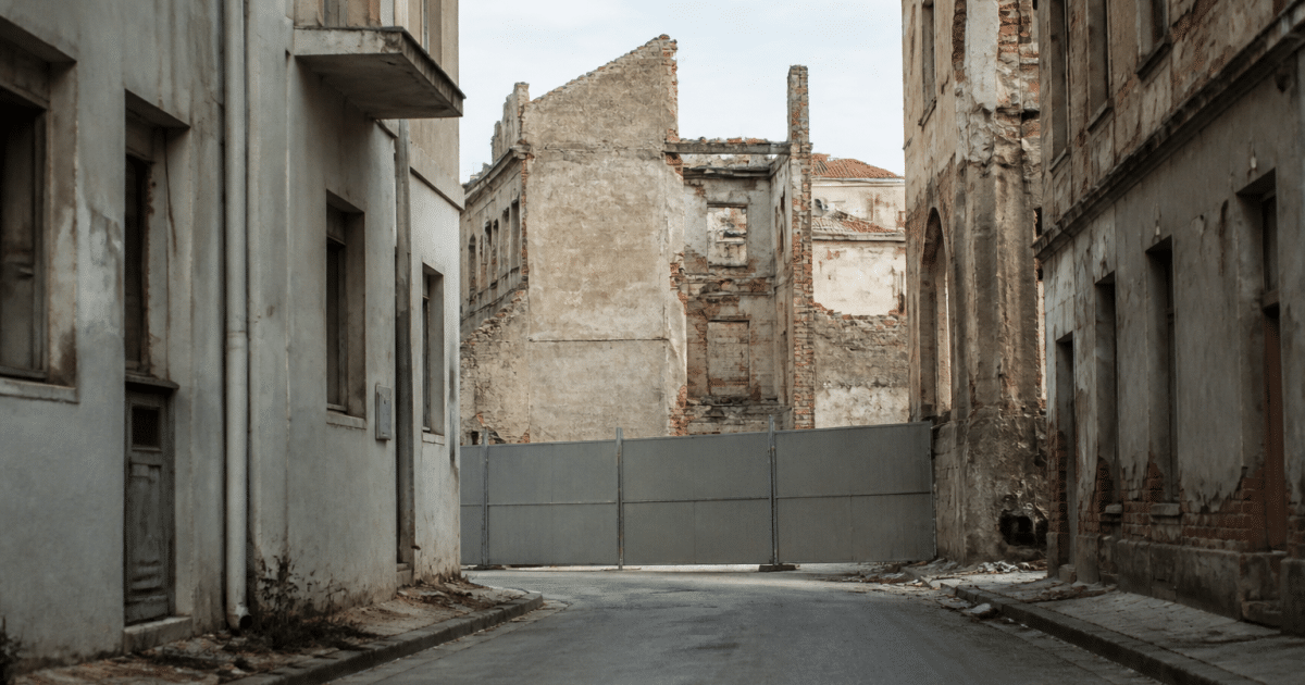 Rue urbaine déserte avec immeubles délabres et panneaux d'avertissement visibles