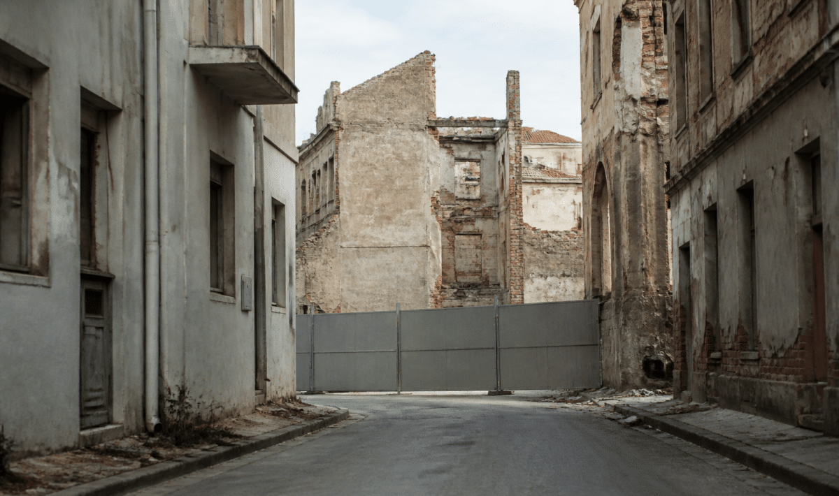 Rue urbaine déserte avec immeubles délabres et panneaux d'avertissement visibles