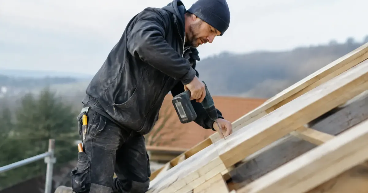 Artisan fixant des planches sur une pente