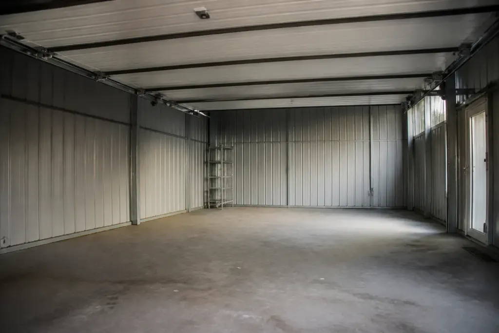 Grand garage avec panneaux metalliques gris et rails visibles