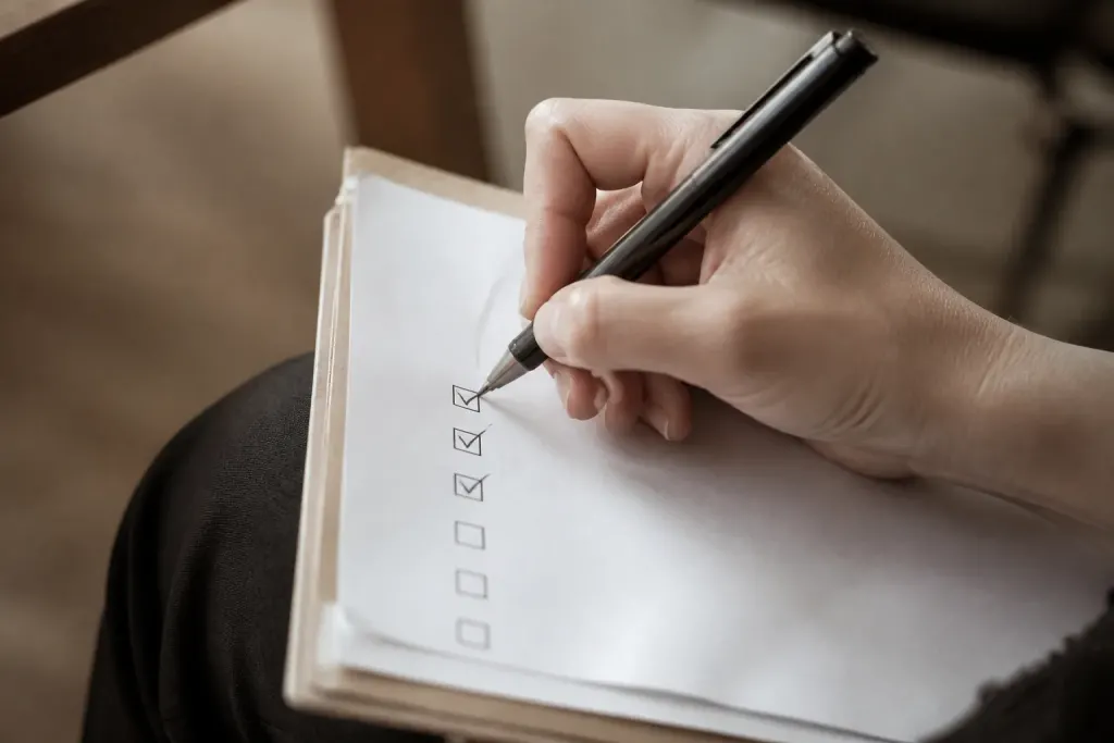 Main cochant une liste sur un dossier papier