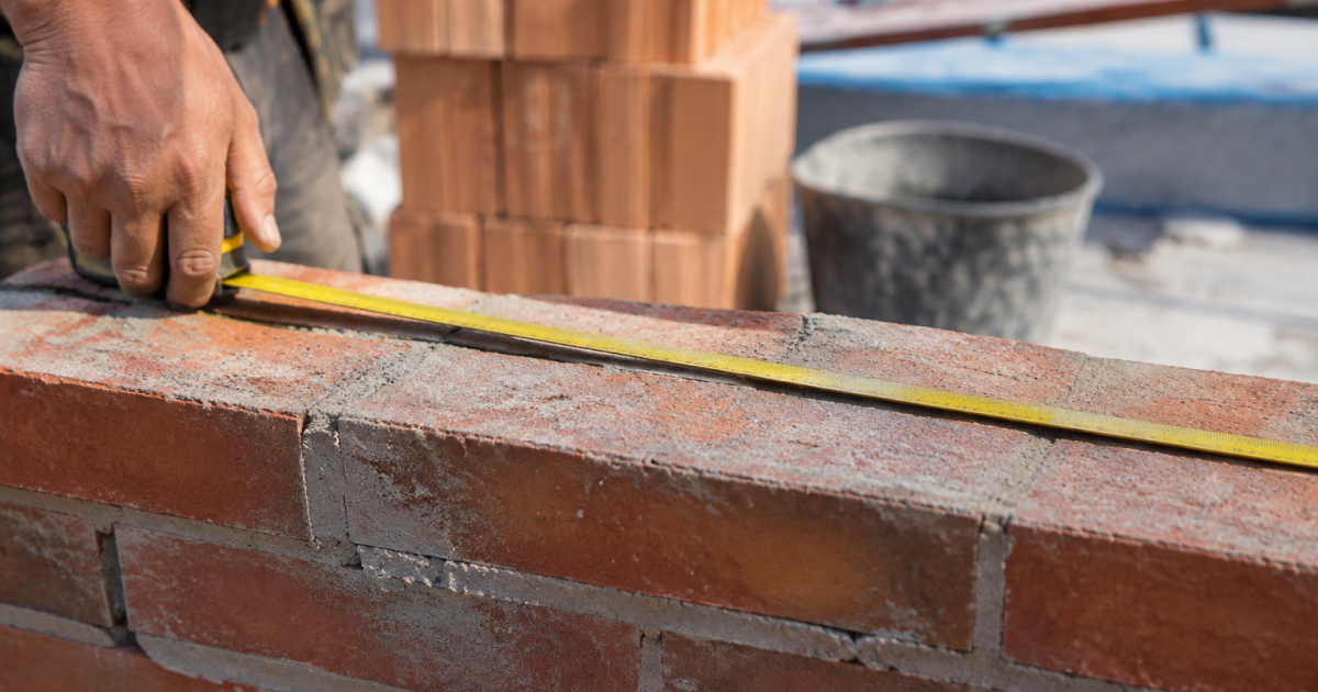 Metre ruban horizontal couvrant surface brique chantier